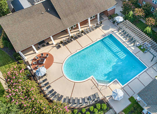 A large swimming pool surrounded by a patio and a deck.