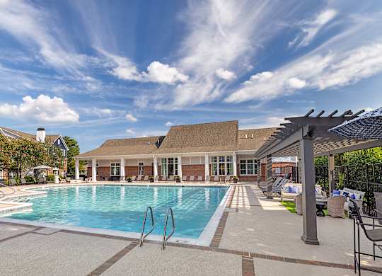 A large swimming pool with a building in the background.