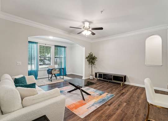 A living room with a white sofa, a coffee table, and a rug.