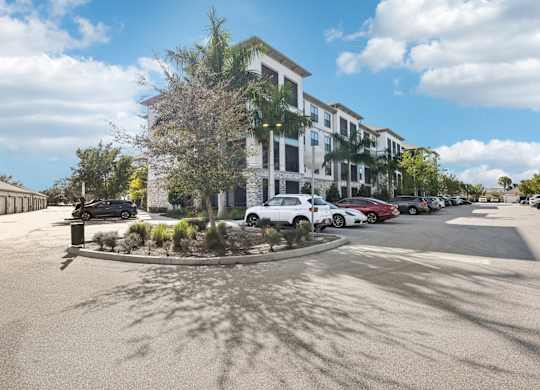 A parking lot with cars and a building in the background.