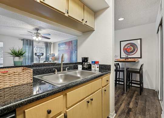 A kitchen with a black countertop and wooden cabinets.