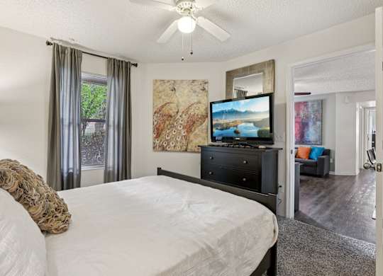 A bedroom with a large bed and a television.