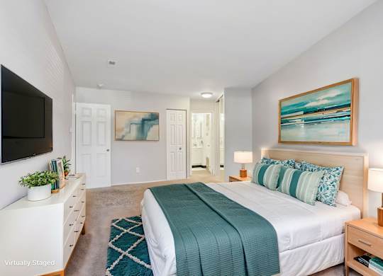 A bedroom with a bed, nightstand, and a painting on the wall. at Millennium at Creve Coeur, Missouri, 63141