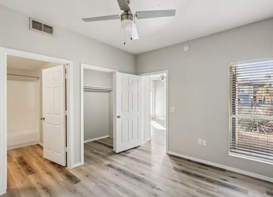 A room with a ceiling fan and a window with blinds at Sweetwater At Metro North Apartments, Arizona