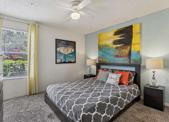 A bedroom with a large bed and a painting on the wall.