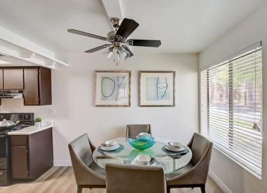 a dining area with a glass table and chairs and a ceiling fan at Glen at Mesa Apartments, AZ 85201