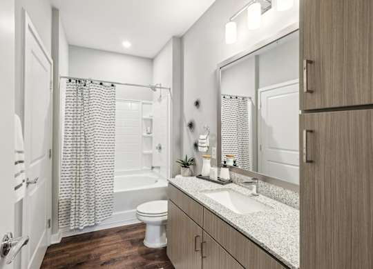 A bathroom with a toilet, sink, and shower.