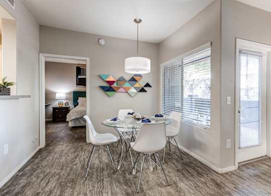 A dining room with a white table and chairs at Sweetwater At Metro North Apartments, Phoenix, AZ