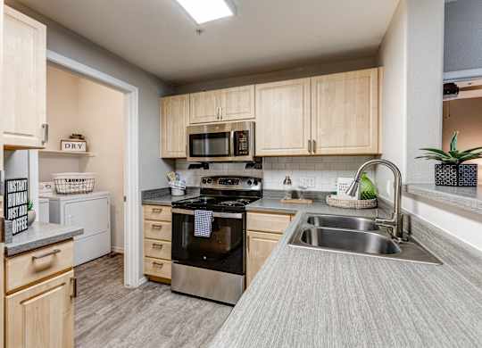 A kitchen with a stove, oven, and sink at Sweetwater At Metro North Apartments, Phoenix
