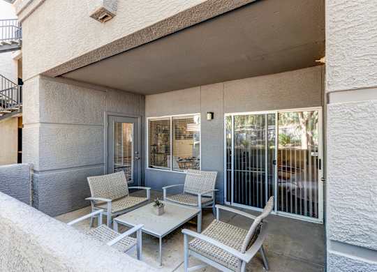 A patio with a table and chairs is on the balcony of a house at Sweetwater At Metro North Apartments, Phoenix, Arizona