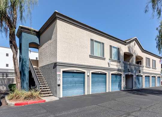 A two-story building with a blue garage door on the ground floor at Sweetwater At Metro North Apartments, Phoenix, AZ