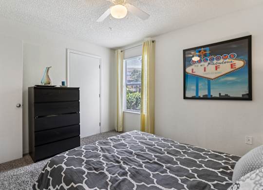A bedroom with a bed, dresser, and a painting on the wall.