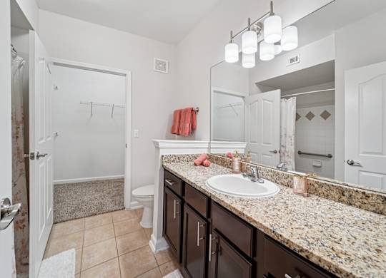 A bathroom with a granite countertop and a white sink.
