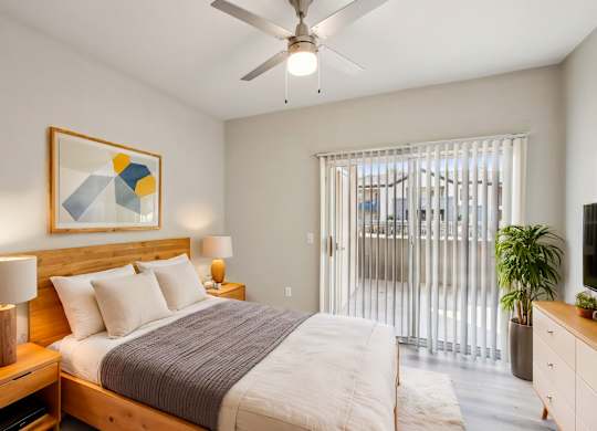 A bedroom with a bed, nightstand, and a painting on the wall at Sweetwater At Metro North Apartments, Arizona