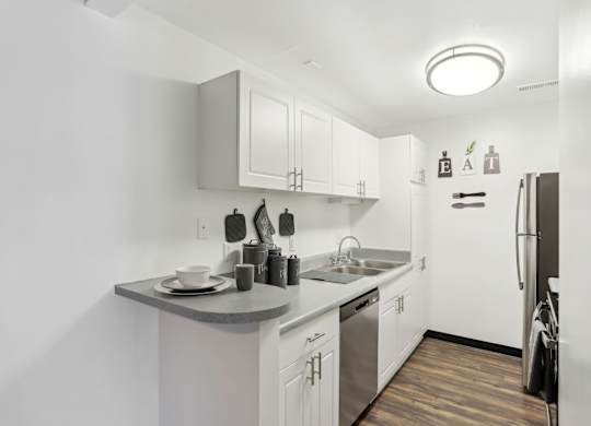 A kitchen with white cabinets and a wooden floor. at Millennium at Creve Coeur, Missouri, 63141