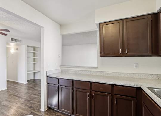 A kitchen with brown cabinets and a white counter.