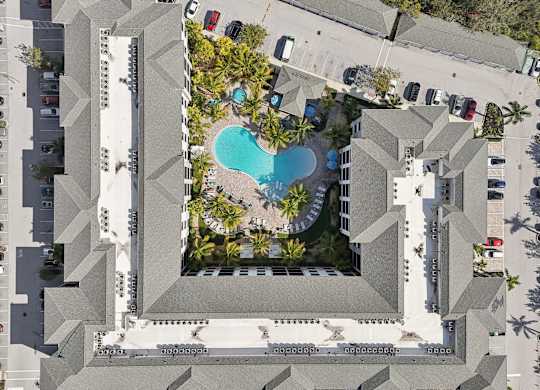 An aerial view of a building with a pool in the middle.