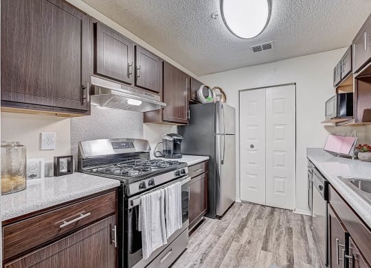 a kitchen with wood cabinets and stainless steel appliances at St. Johns Forest Apartments, Florida, 32277