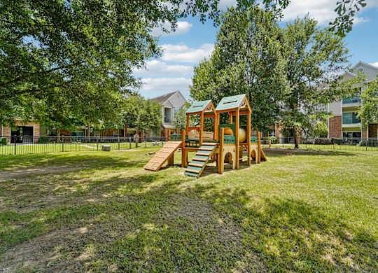 A playground with a wooden swing set and a green roof.