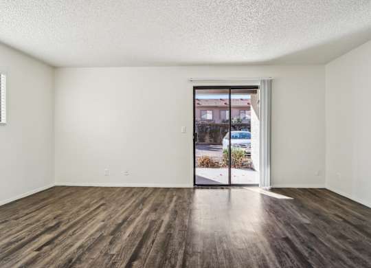 A room with a sliding glass door leading to a street.
