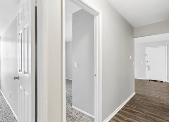 A white door is open to a room with a carpeted floor. at Millennium at Creve Coeur, Missouri, 63141