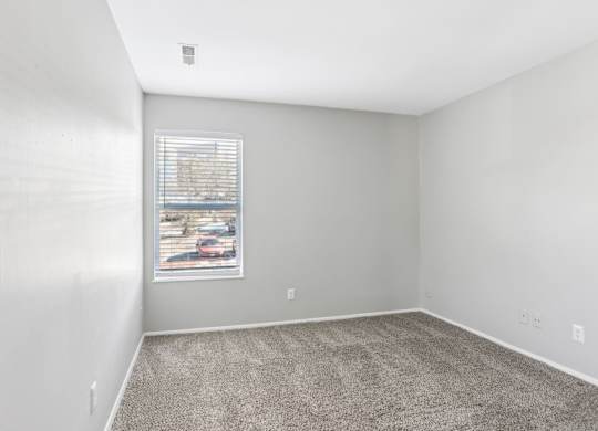 A room with a carpeted floor and a window with blinds. at Millennium at Creve Coeur, Creve Coeur
