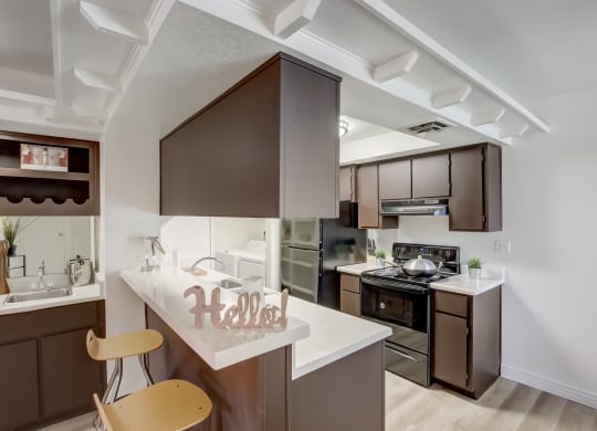 a kitchen with brown cabinets and white countertops at Glen at Mesa Apartments, AZ 85201