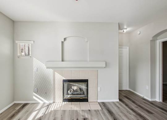A modern living room with a fireplace and wood flooring at Sweetwater At Metro North Apartments, Phoenix, AZ 85029