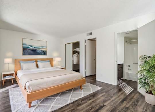 A bedroom with a large bed and a painting on the wall.