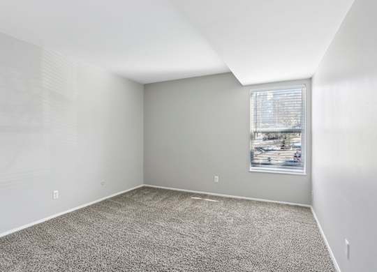 A room with a carpeted floor and a window with blinds. at Millennium at Creve Coeur, Missouri, 63141