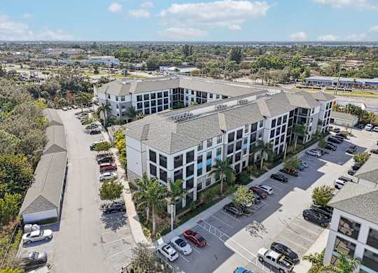 A large white building with a parking lot in front of it.