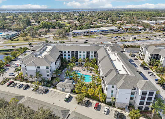 A large white building with a pool in front of it.