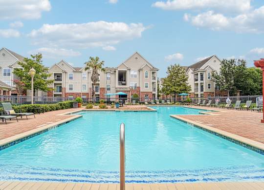 A swimming pool in front of a row of houses.
