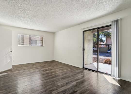 A room with wooden floors and a sliding glass door.