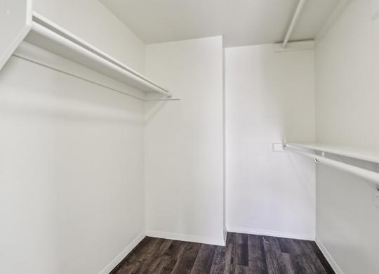 A white room with a wooden floor and a white door.