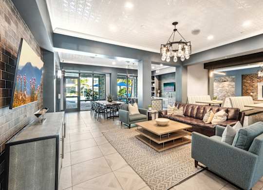 A modern living room with a grey couch and a chandelier.