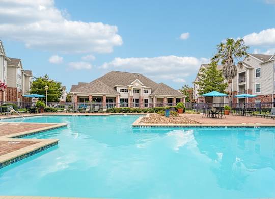 A large swimming pool in front of apartment buildings.