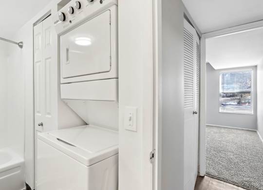 A white oven and microwave are built into a wall in a kitchen. at Millennium at Creve Coeur, Missouri