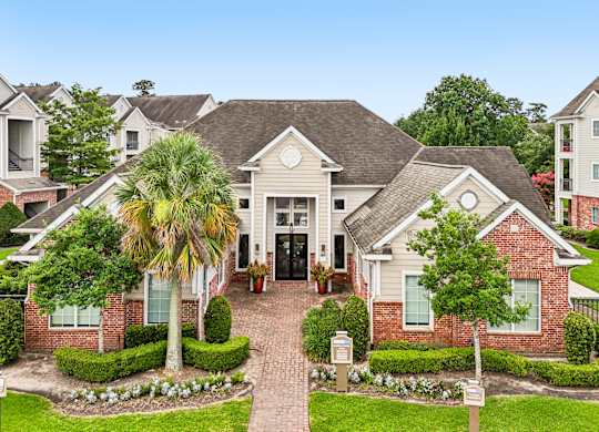 A house with a brick front yard and a palm tree.