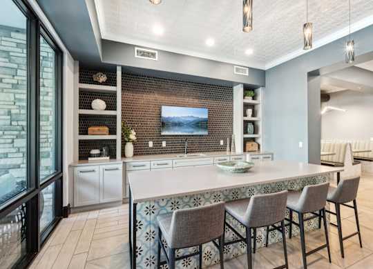 A modern kitchen with a large island and a television mounted on the wall.