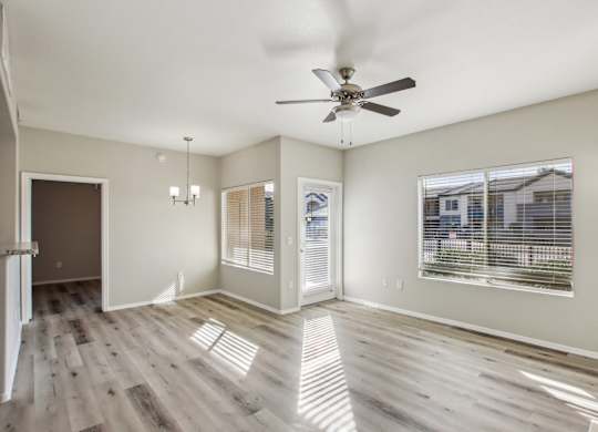 A spacious room with a ceiling fan and wooden flooring at Sweetwater At Metro North Apartments, Arizona 85029