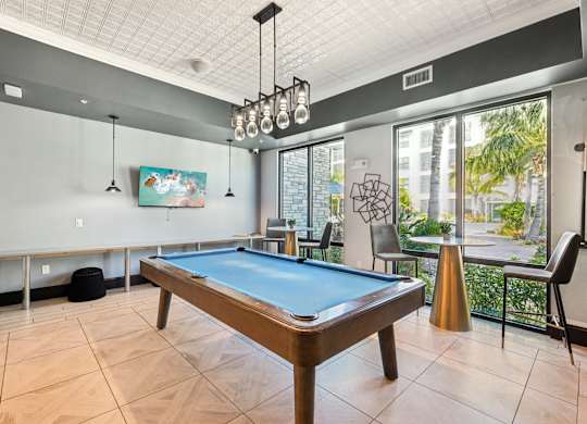 A pool table in a room with a painting on the wall.