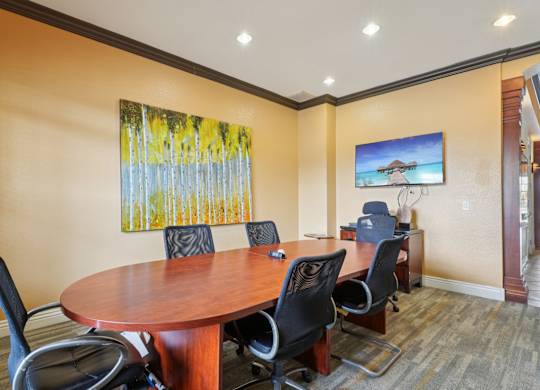 A conference room with a large table and chairs.