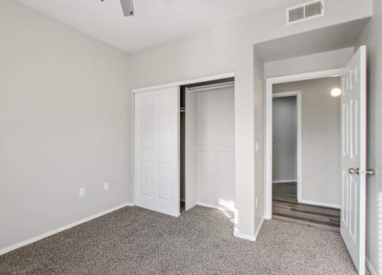 A room with a carpeted floor and white walls at Sweetwater At Metro North Apartments, Arizona 85029
