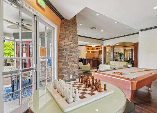 A pool table with a chess board on top of it.