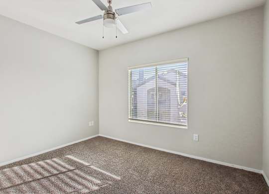 A room with a ceiling fan and a window at Sweetwater At Metro North Apartments, Phoenix  85029