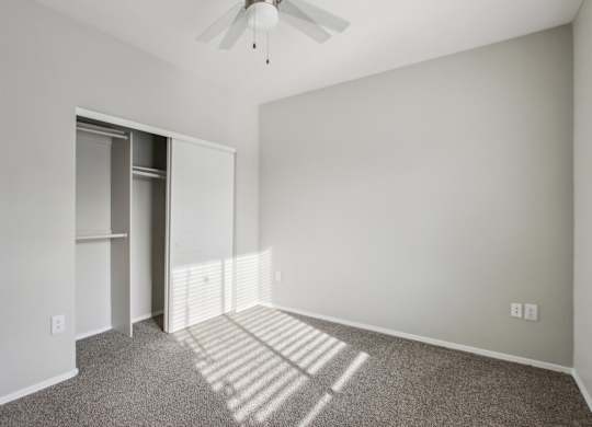 A room with a ceiling fan and a carpeted floor at Sweetwater At Metro North Apartments, Phoenix  85029