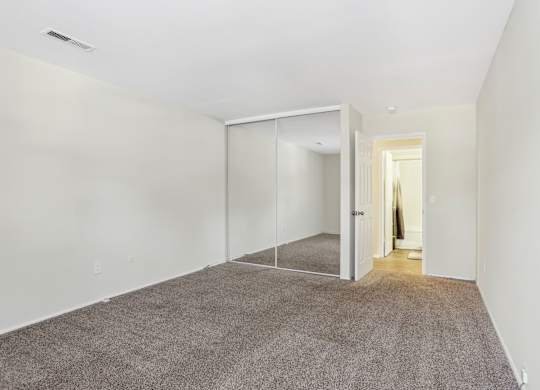 A room with a carpeted floor and a glass door. at Millennium at Creve Coeur, Creve Coeur