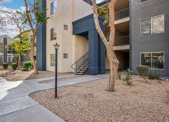A tree in front of a building with a black lamp post at Sweetwater At Metro North Apartments, Phoenix, Arizona