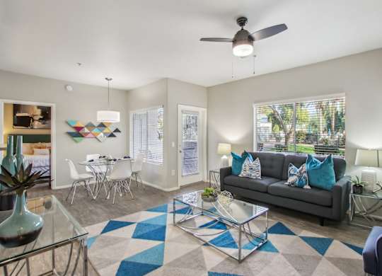 A living room with a grey couch and a glass coffee table at Sweetwater At Metro North Apartments, Arizona